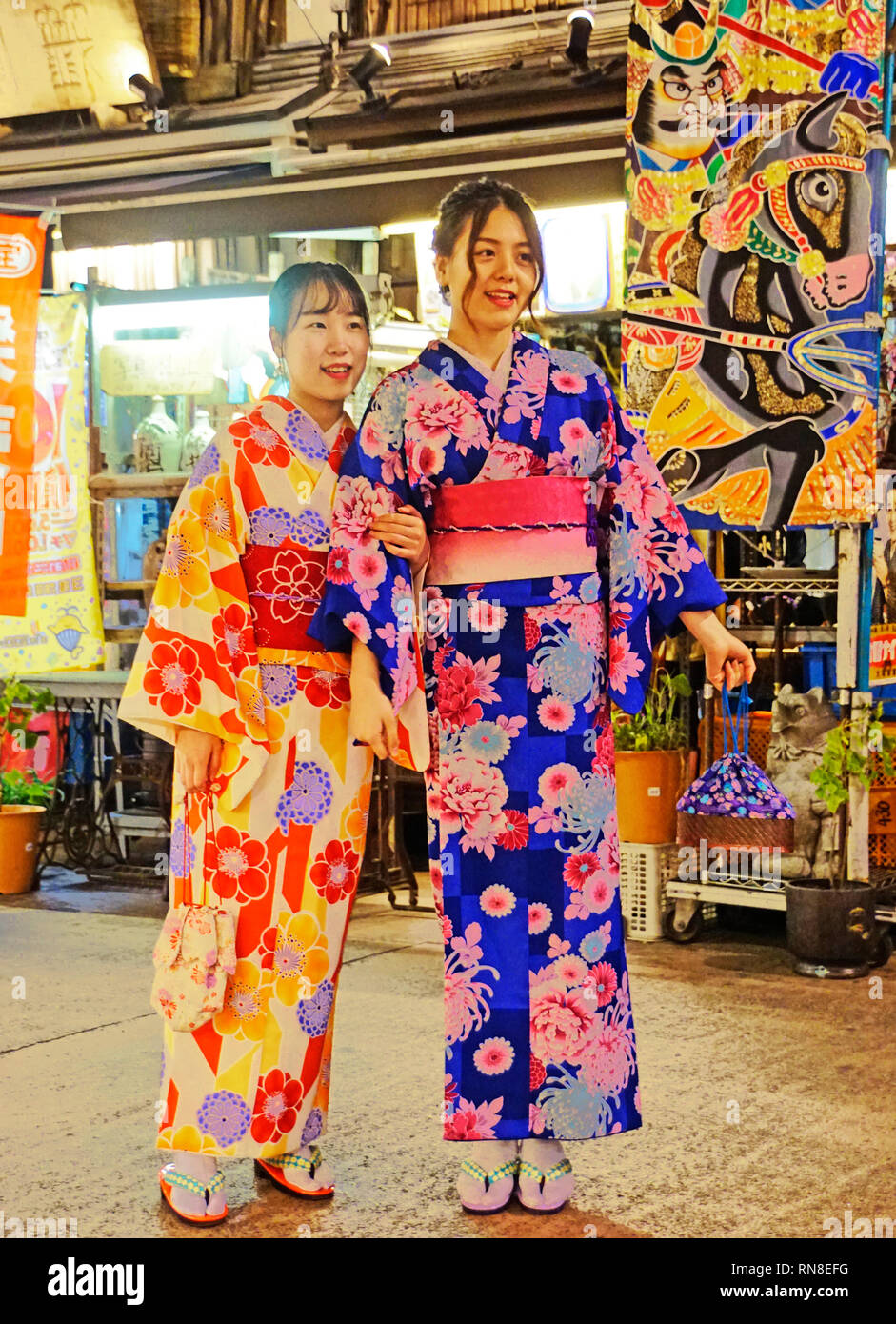 Young women tourists wearing rental kimonos on night out in Asakusa  neighborhood of old Tokyo Stock Photo - Alamy
