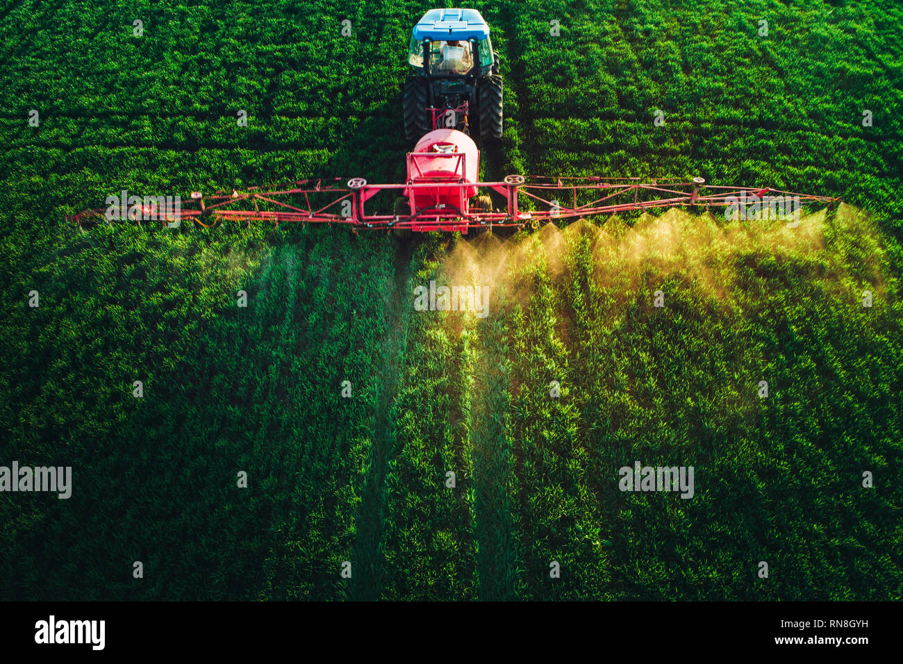 Aerial view of farming tractor plowing and spraying on field Stock ...