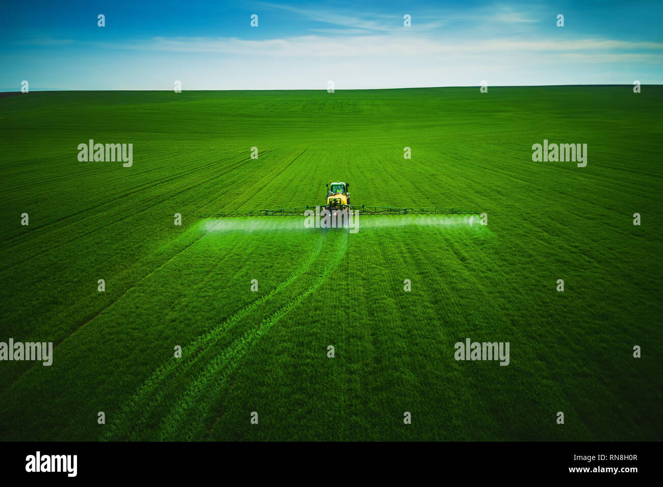 Aerial view of farming tractor plowing and spraying on field Stock ...