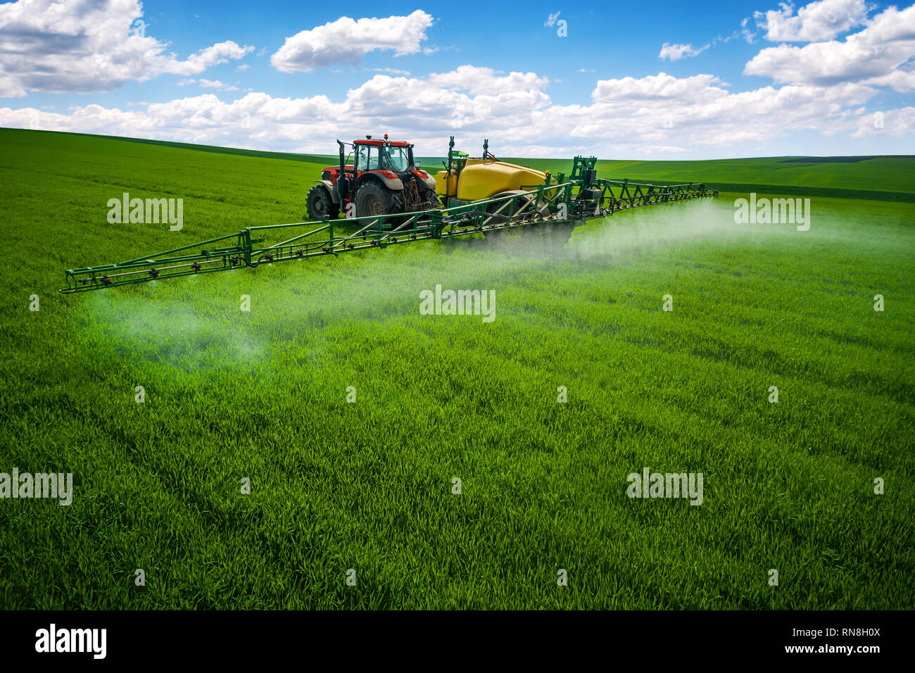 Aerial view of farming tractor plowing and spraying on field Stock ...