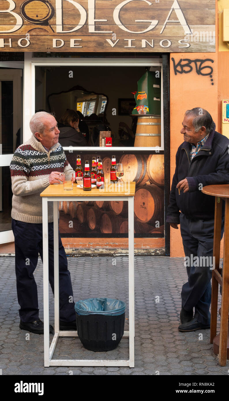 Two senior men having a talk and a few beers at an outside bar in Seville, Spain Stock Photo Alamy