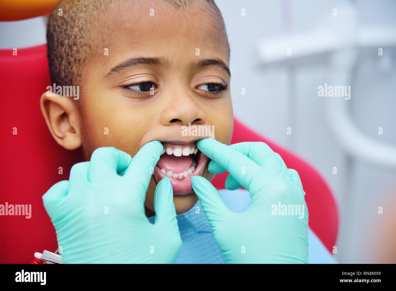 cute black baby boy African American smiling sitting in the dental chair  Stock Photo