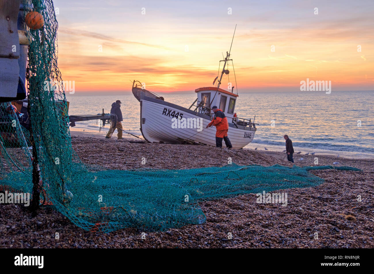 Hastings, East Sussex, UK. Hastings fishing boat being launched at sunrise. Hastings has the largest beach-launched fishing fleet in Europe. Stock Photo