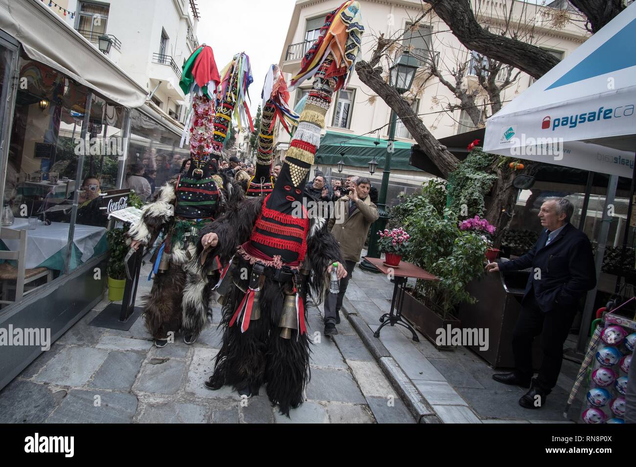 Participants seen wearing masks and dancing during the custom. Bell Wearers present their customs with dances and music in Athens, Greece. A custom from Serres where the participants wear bells and big masks with colors. Stock Photo