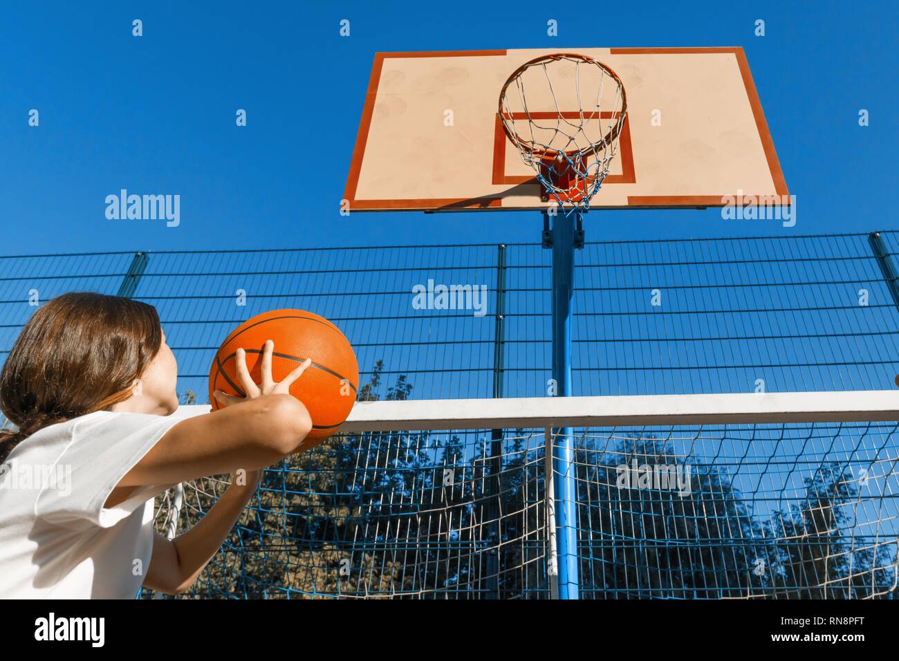 Teenager girl street basketball player with ball on outdoor city