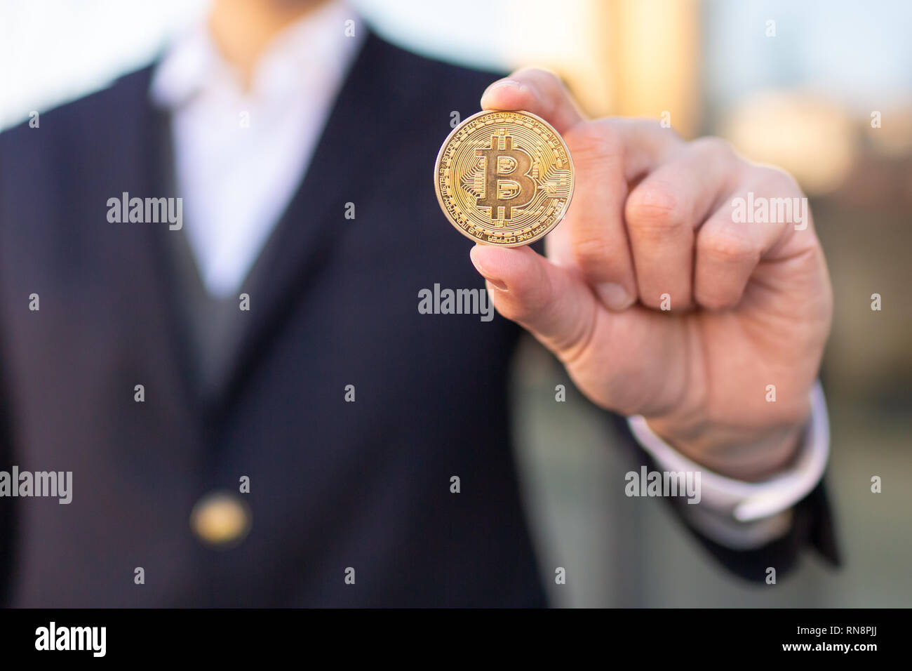 Bitcoin cryptocurrency coin in a young businessman hand. Disruptive  blockchain technology concept and transfer of wealth Stock Photo - Alamy
