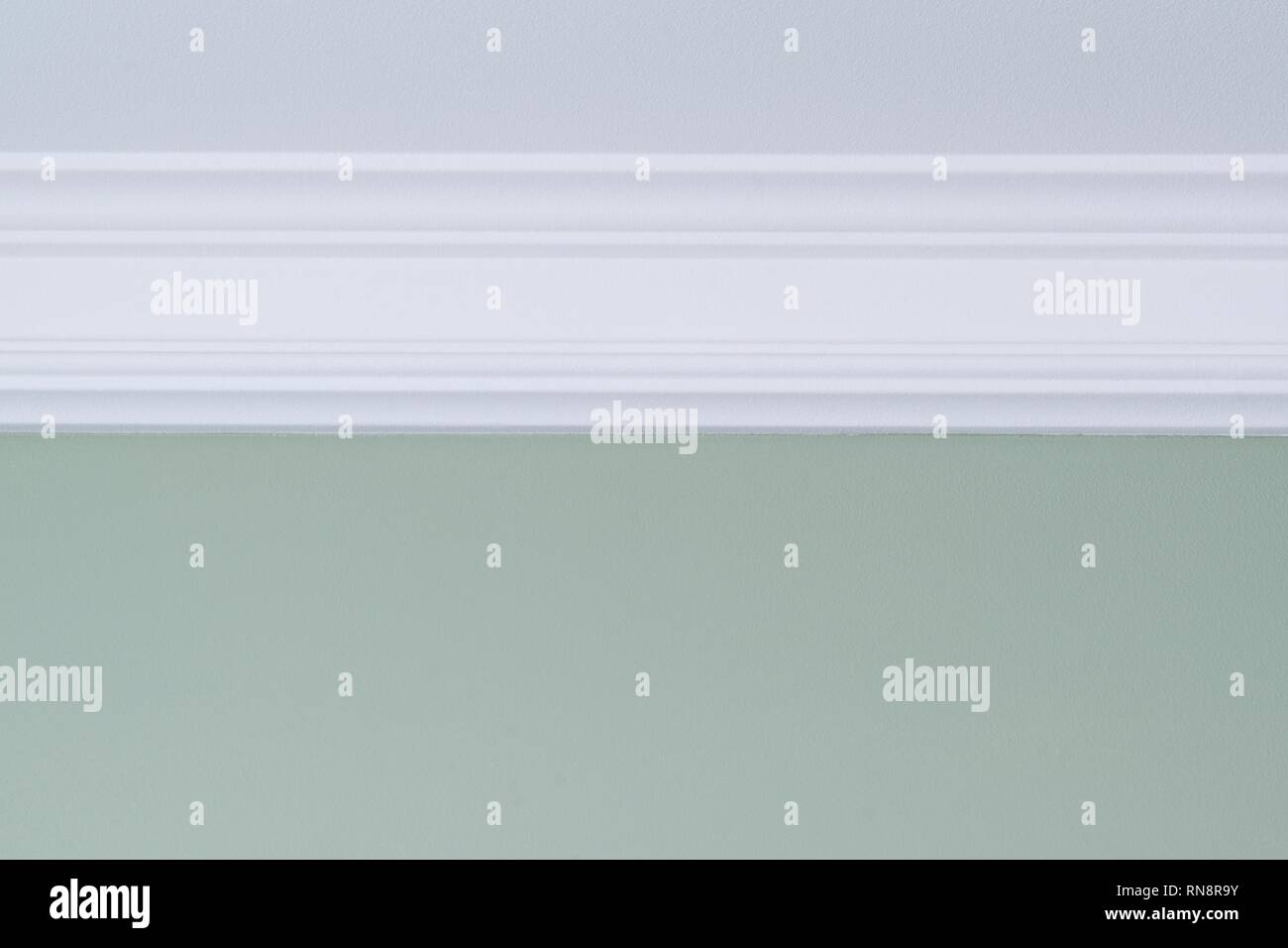 White ceiling molding, green painted wall. Interior details close-up. Stock Photo