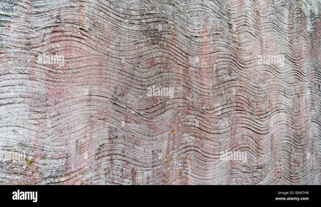 Abstract irregular wavy lines in cement rendered wall with light faded