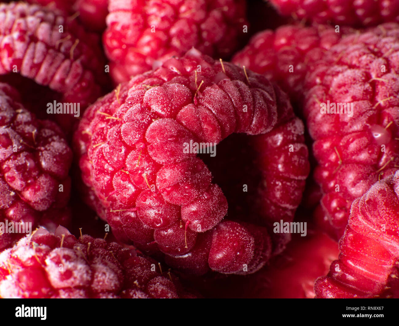 Healthy breakfast: Close up of frozen raspberries, macro shot, top view, vibrant  colors Stock Photo