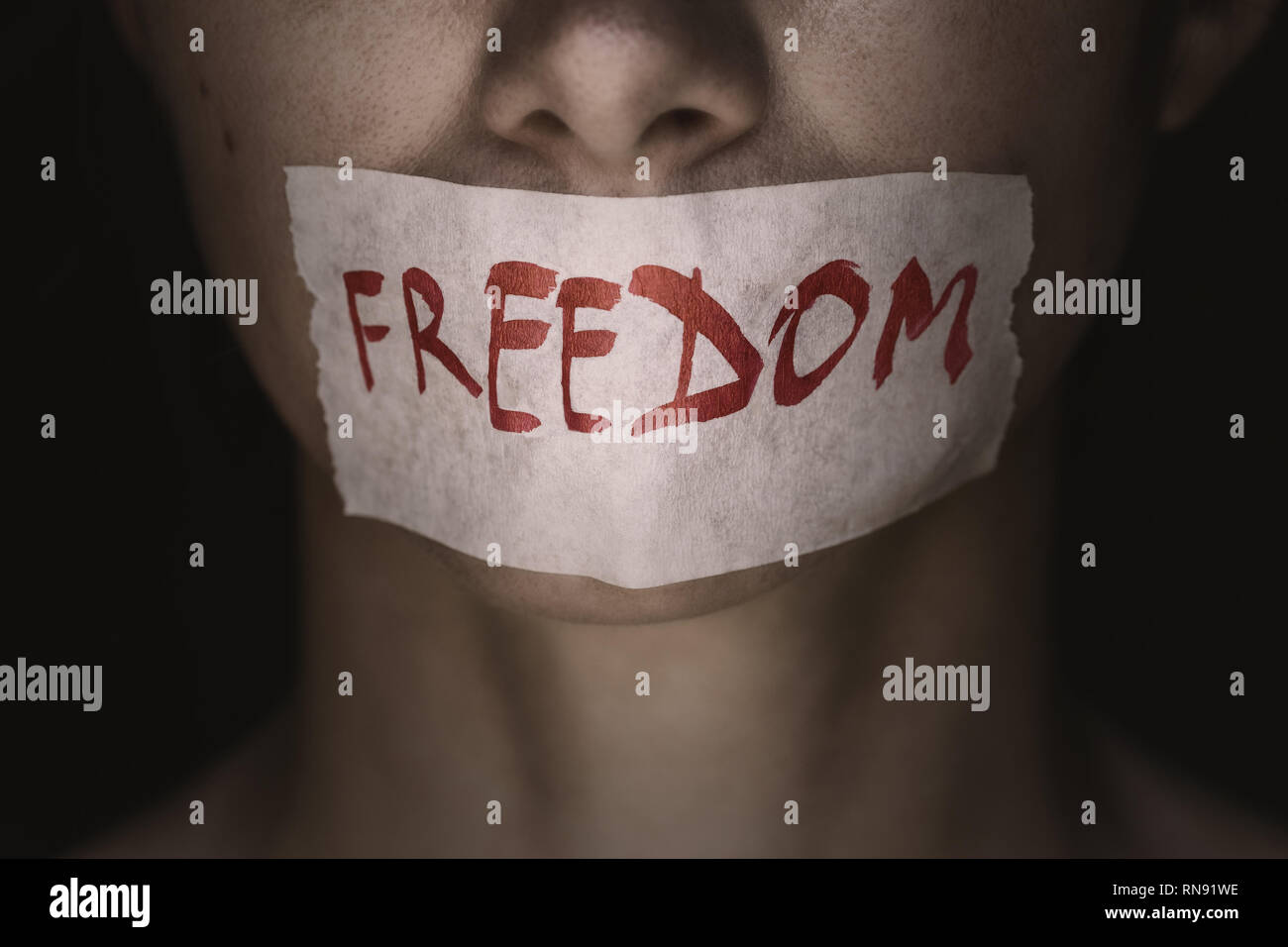 Freedom of speech: girls face is sealed with tape, close-up Stock Photo
