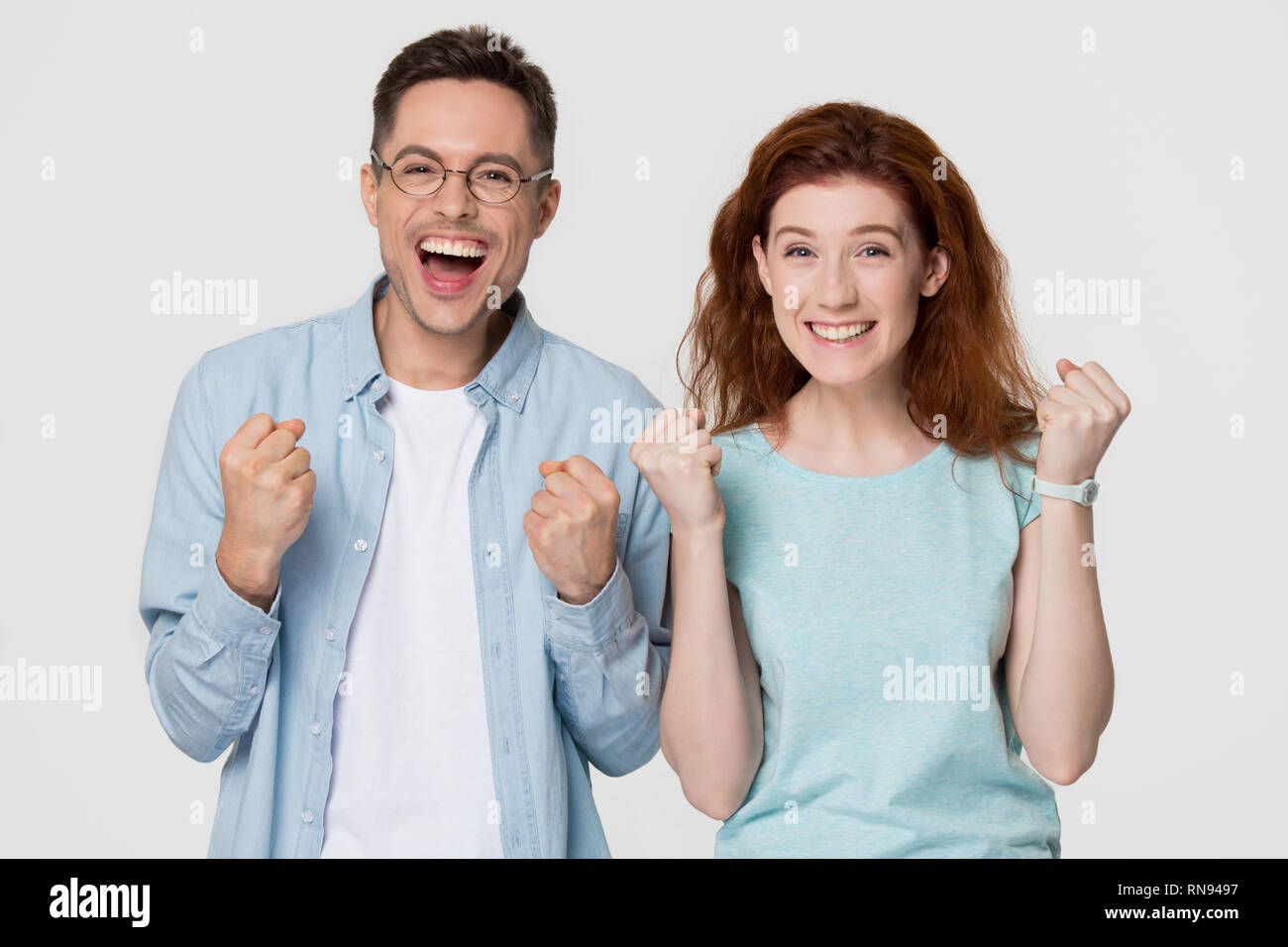 Excited happy couple winners celebrate victory looking at camera Stock Photo