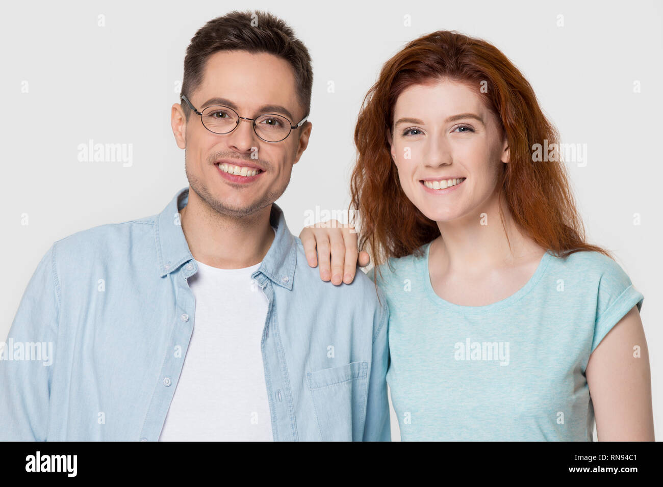 Young happy romantic couple looking at camera isolated on background ...