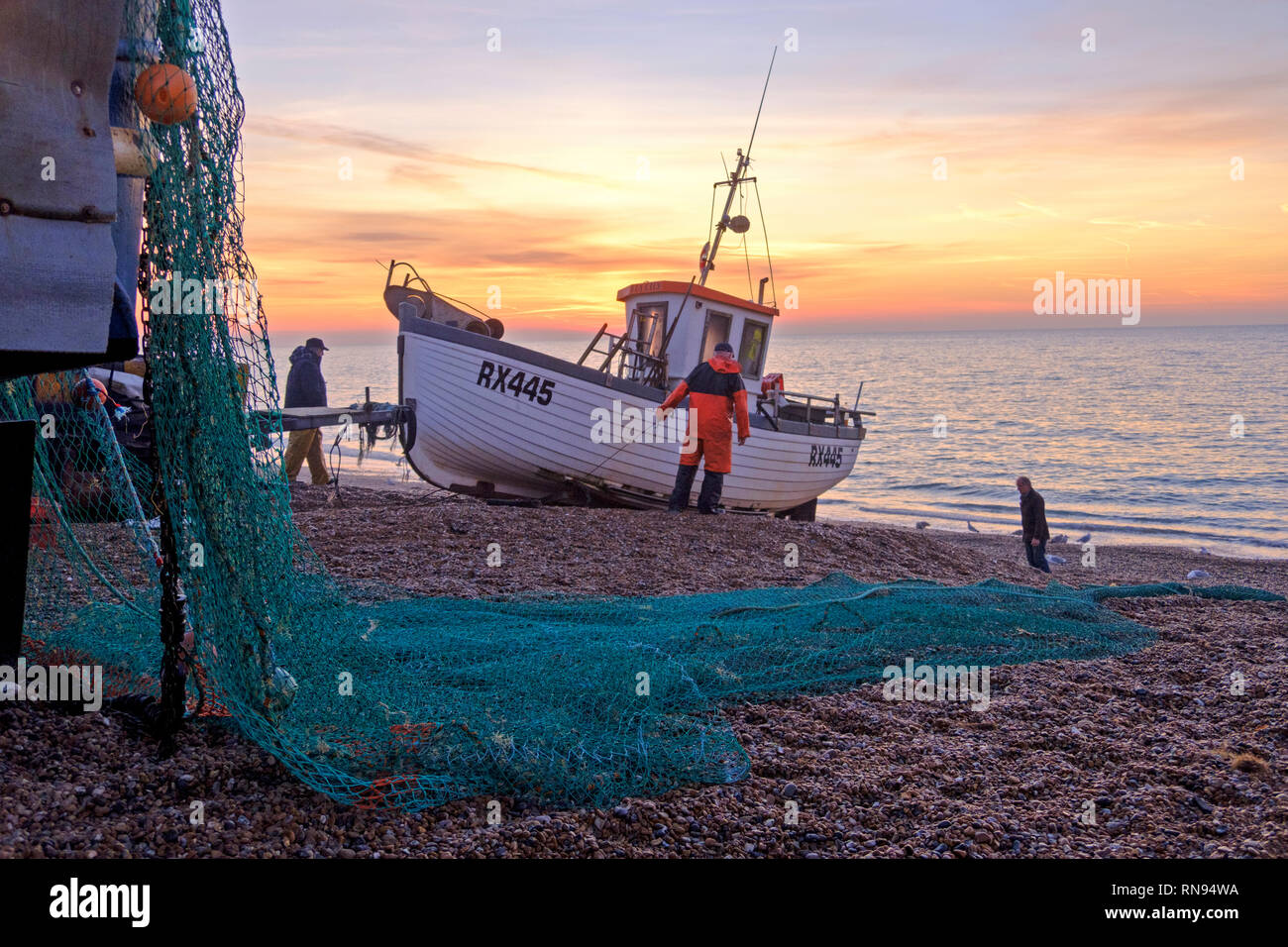 Hastings, East Sussex, UK. Hastings fishing boat being launched at sunrise. Hastings has the largest beach-launched fishing fleet in Europe Stock Photo