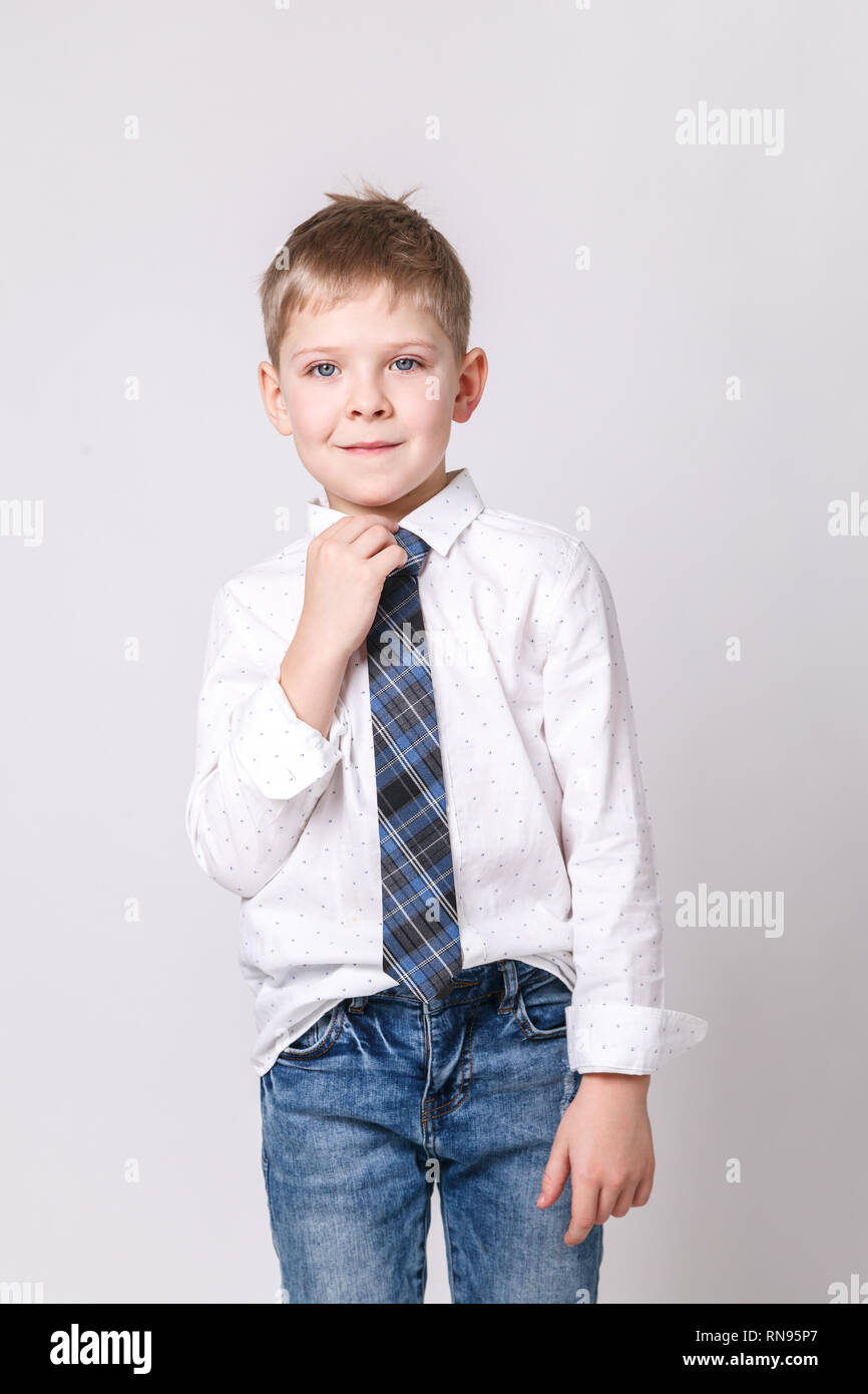 Cute little smiling boy in white shirt and in a stylish tie posing on a  light-gray background. Portrait of fashionable male child, gray wall on  backgr Stock Photo - Alamy