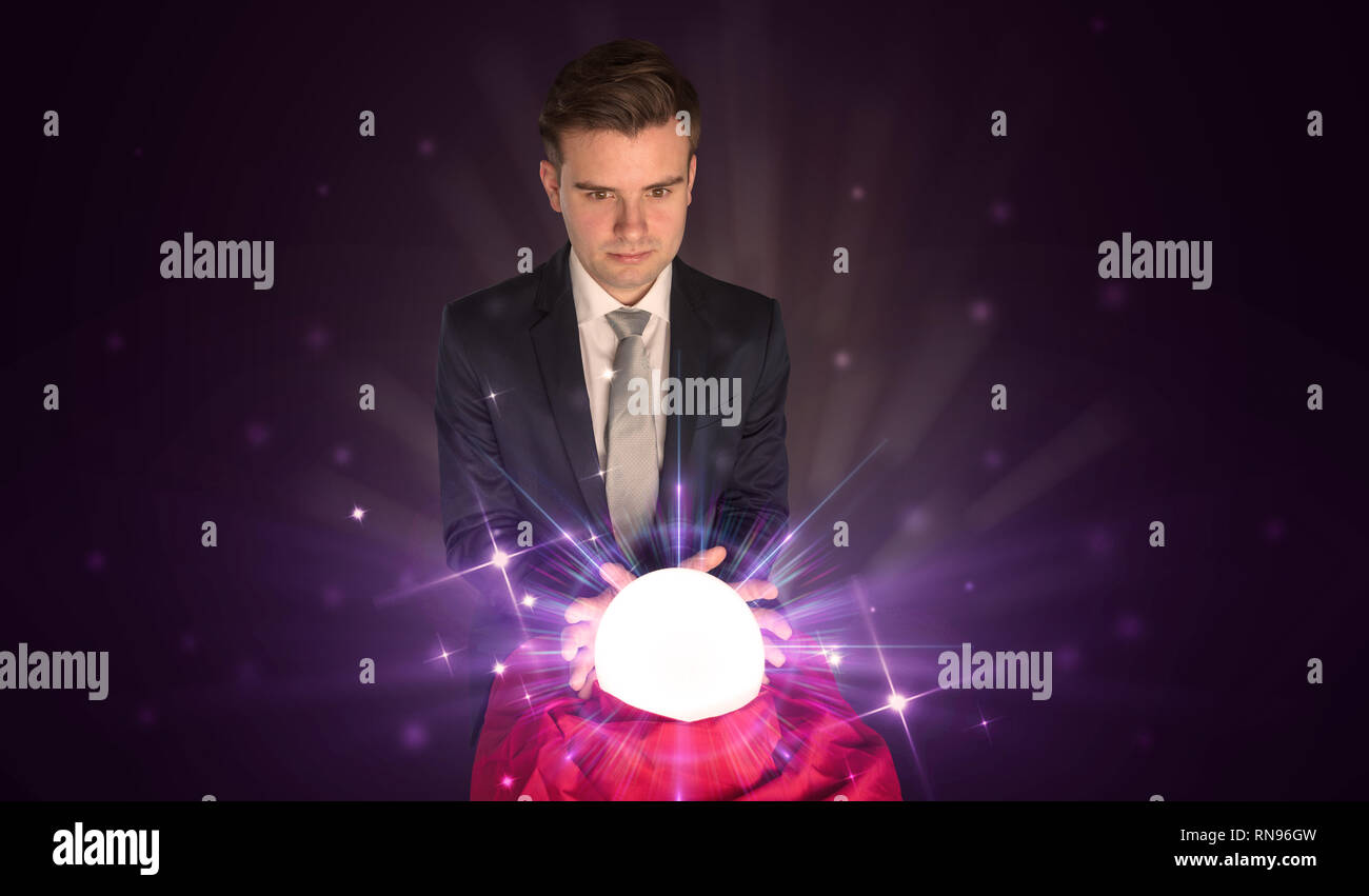 Young businessman sitting with crystal ball in action Stock Photo - Alamy