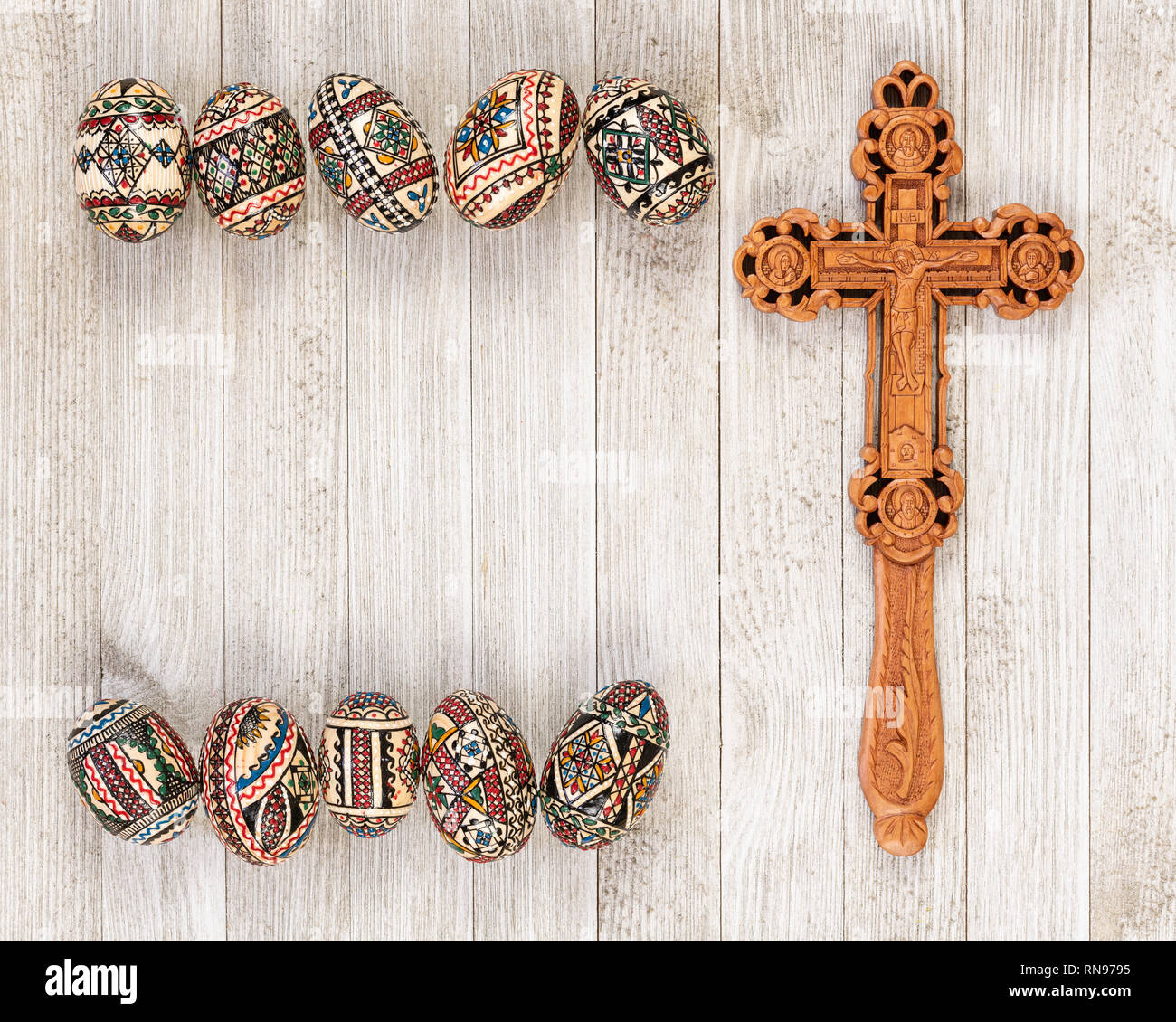 Painted wooden eggs traditional of Eastern Europe with delicately sculpted wooden cross and copy space. Stock Photo