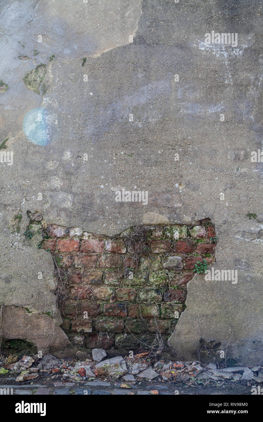 Plaster Missing from Wall Showing Brickwork Underneath Stock Photo