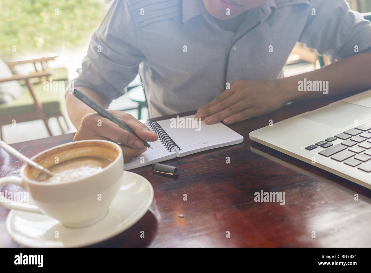 Young Asian freelancer writing important ideas into notes Stock Photo ...