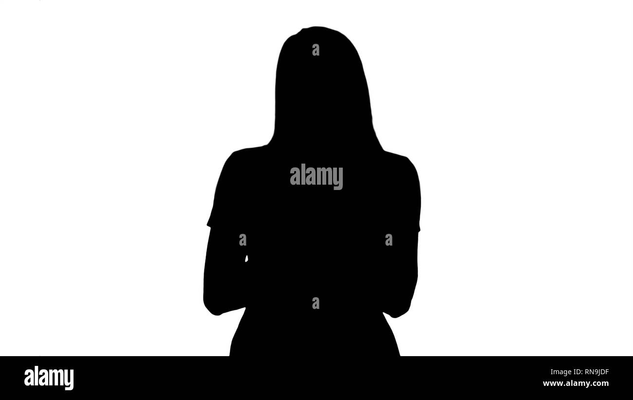 Silhouette Portrait of smiling young lady reading text message on her mobile phone. Stock Photo