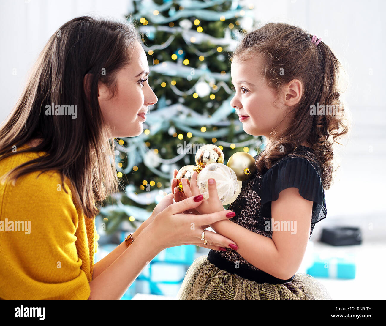 Mother and daughter holding colorful glass balls Stock Photo