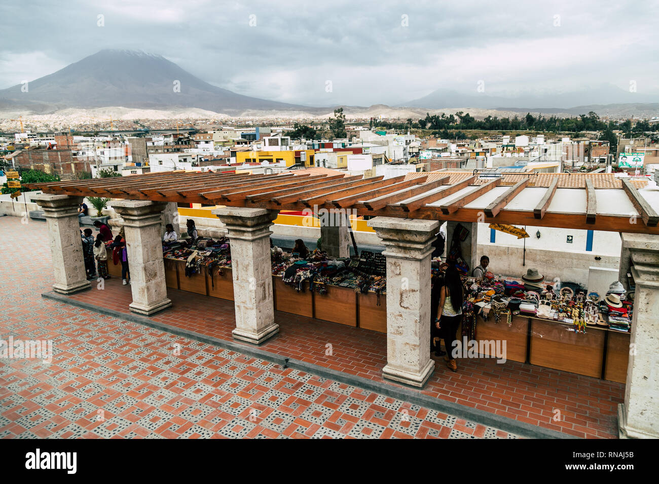 Vendors of artisanal products on a square in the White City (Arequipa, Peru) with the city and volcano Misti in the background. Stock Photo