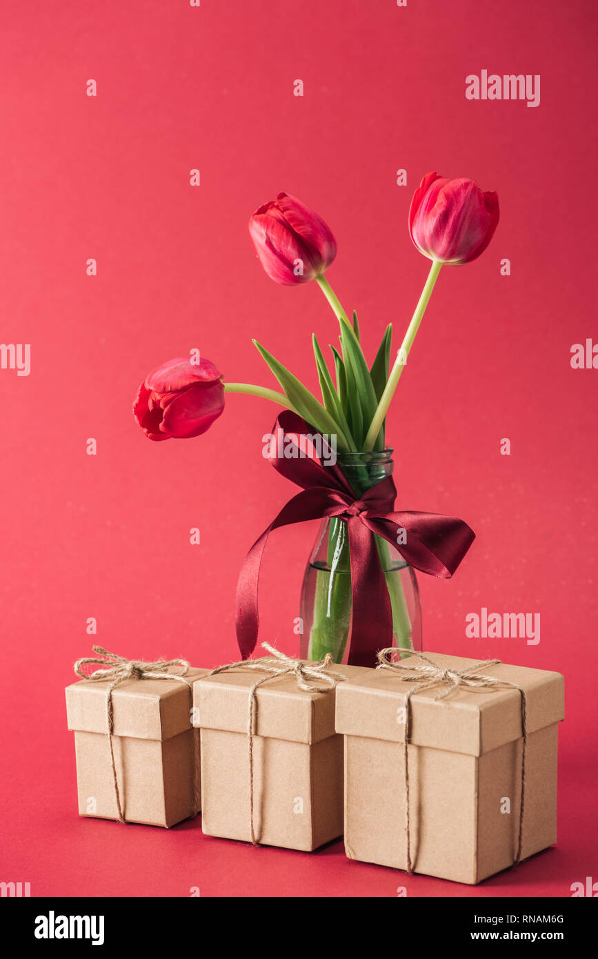 Gift Boxes And Bouquet Of Red Tulips With Red Satin Bowl In Glass