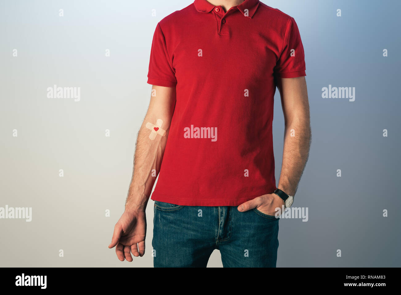 Cropped view of patient in red t-shirt and blue jeans with plasters, blood donation concept Stock Photo