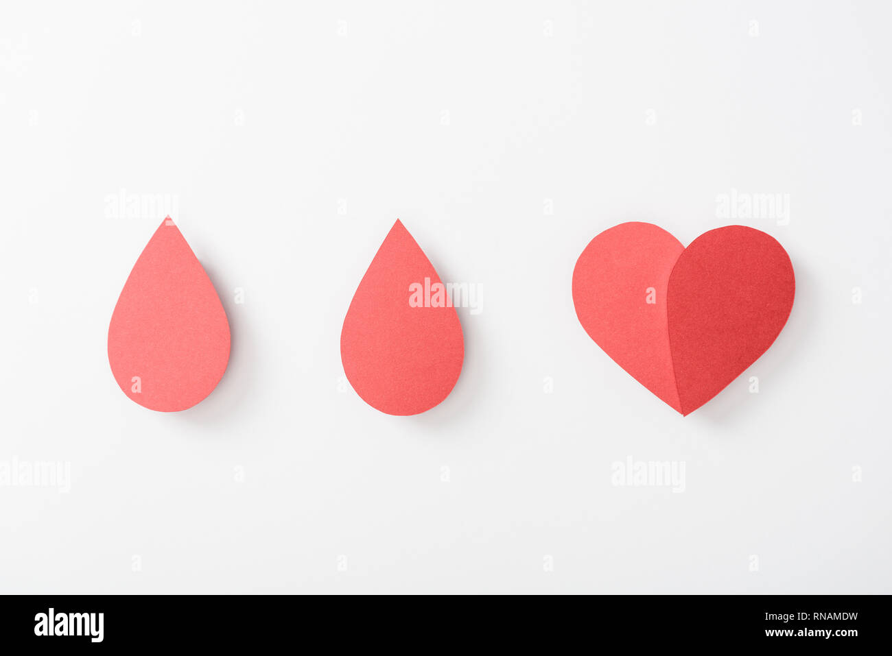Top view of paper heart and drops on white background Stock Photo