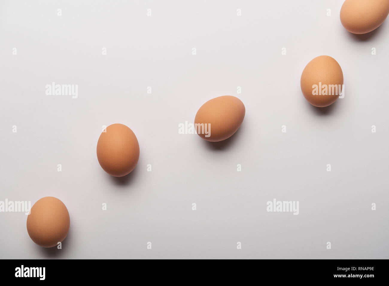 top view of organic eggs arranged in wavy line on grey background Stock Photo