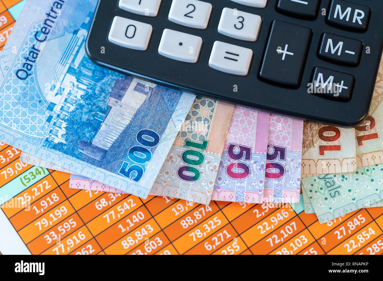 Qatar Riyal Bank Notes on spreadsheet report background With Calculator  Stock Photo - Alamy