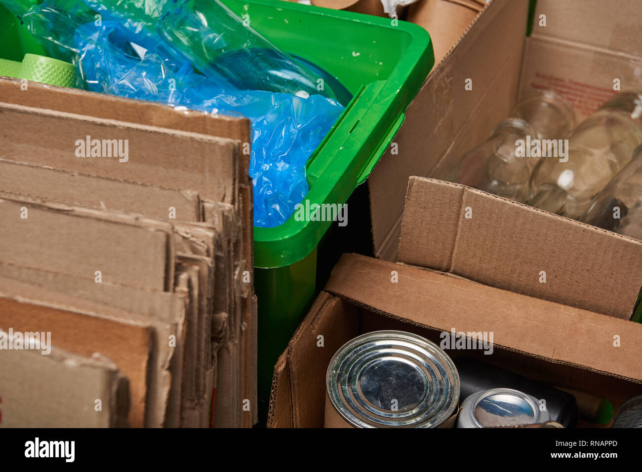 sorted trash of cardboard, glass and plastic bottles, polyethylene, iron cans Stock Photo