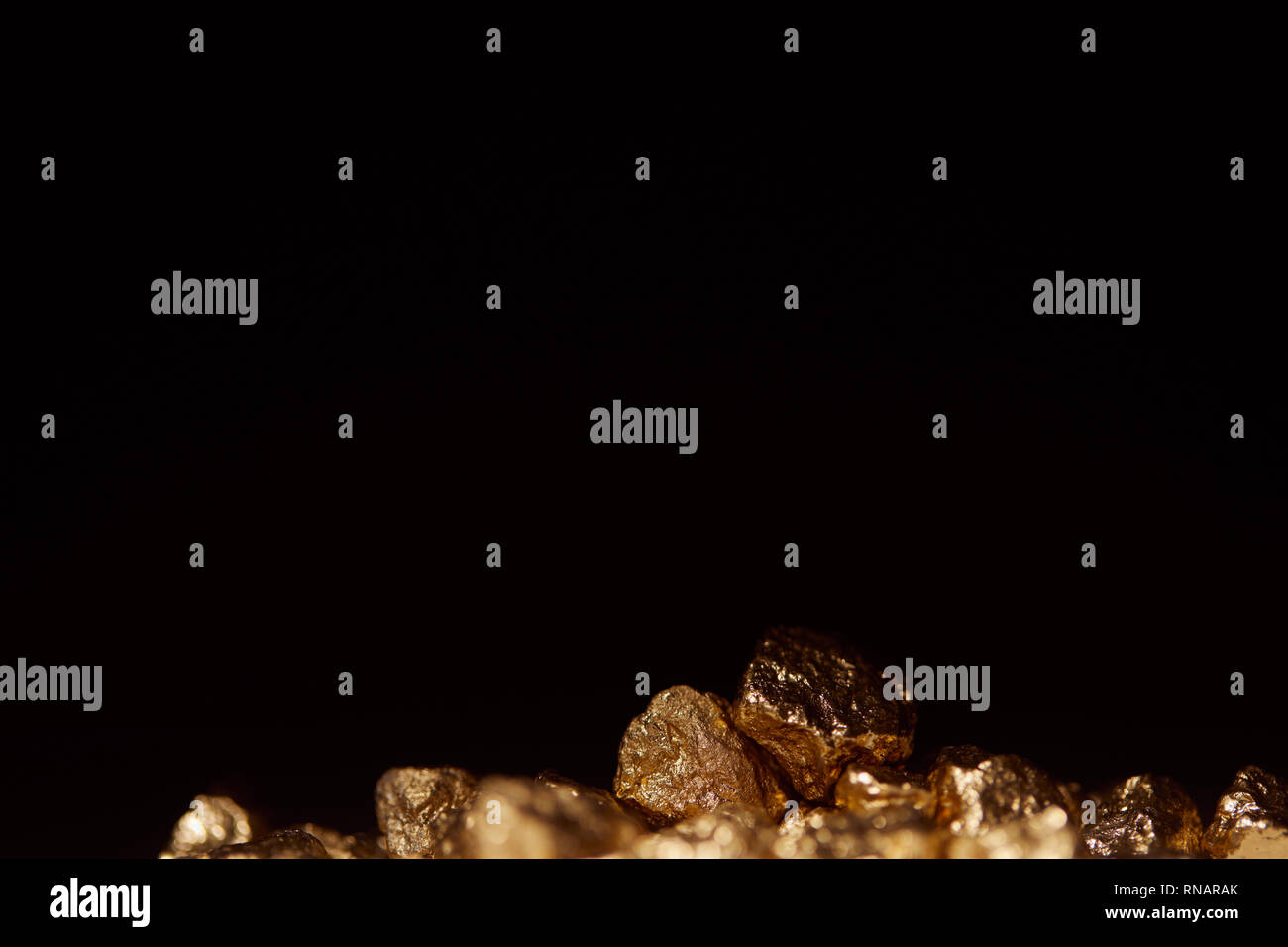 golden stones with blurred foreground isolated on black Stock Photo