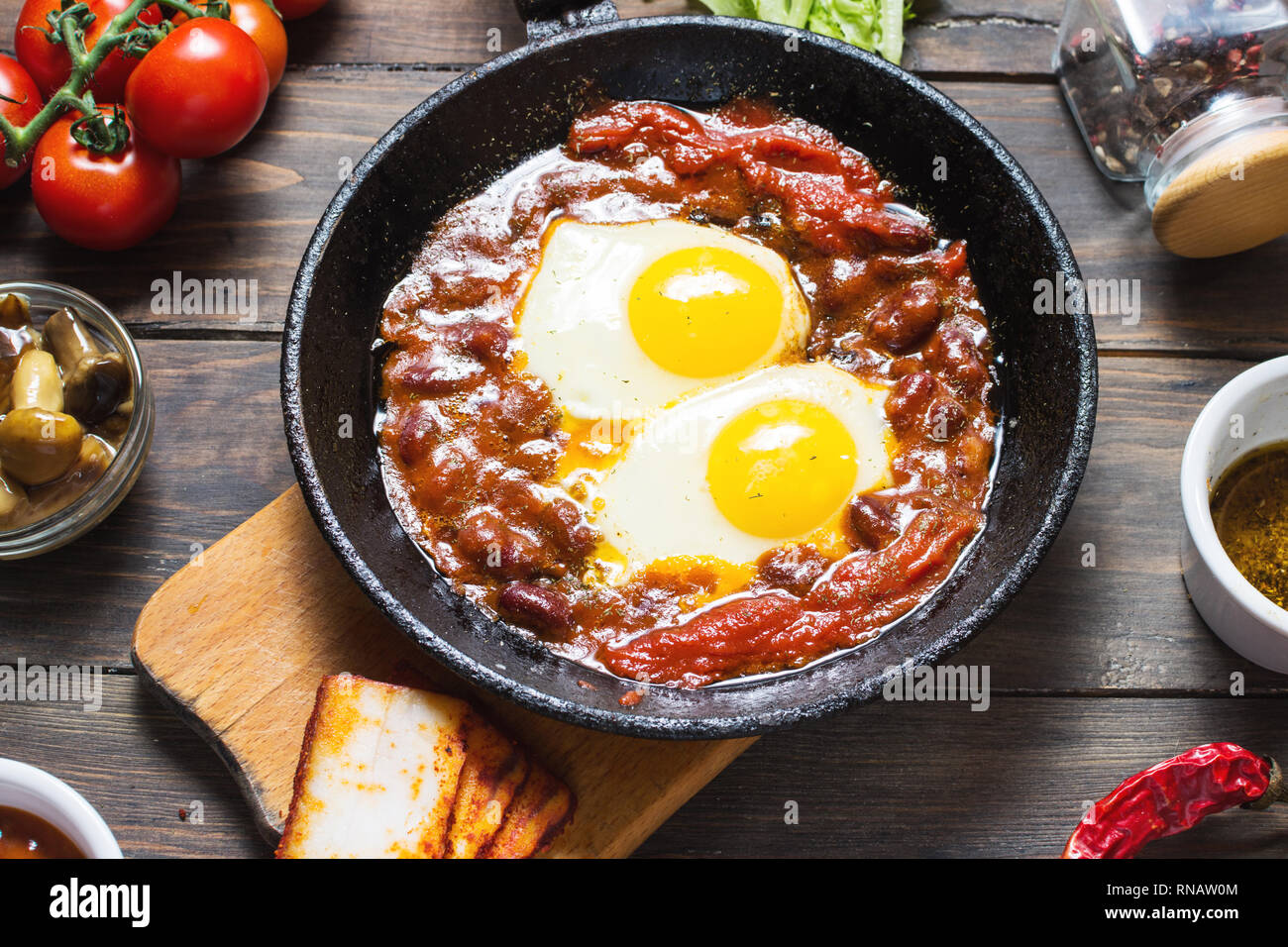 Shakshuka, Fried Eggs in Tomato Sauce in iron frying pan. Typical