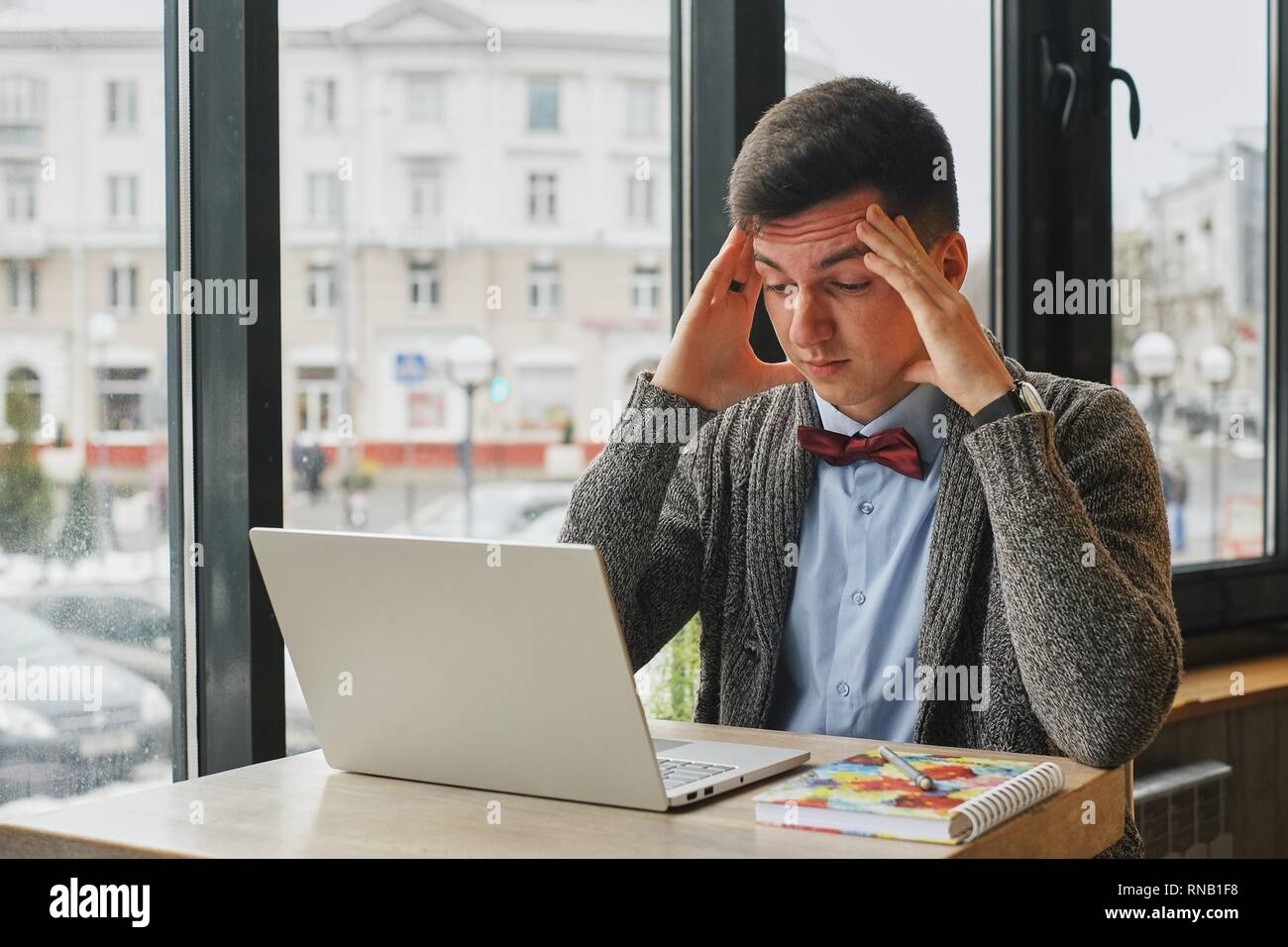 Young tired, ill, overworked man in formal wear sitting in front of ...