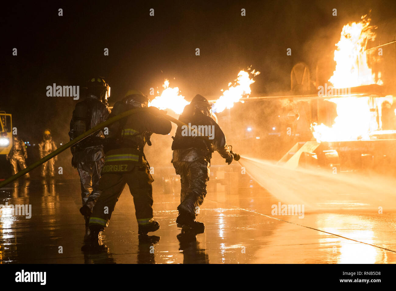 U.S. Marines with Aircraft Rescue and Fire Fighting (ARFF) conduct Hand Line Drills at Marine Corps Air Station (MCAS) Yuma Feb. 15, 2019. These drills focus on techniques to push fuel fires away from aircraft and simulate large aircraft fire fighting. The Marines train monthly to enhance their readiness when responding to hazards or emergencies on the flight line. (U.S. Marine Corps photo by Cpl. Sabrina Candiaflores) Stock Photo
