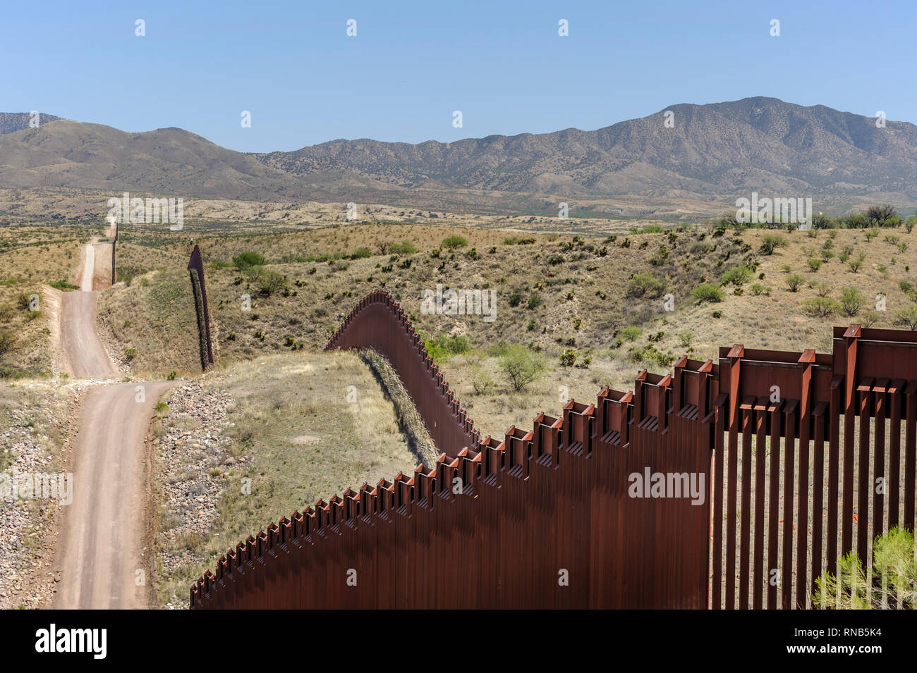 US border fence on Mexico boundary, bollard style pedestrian barrier, US side, looking east, hills and mountains, east of Nogales Arizona, April 2018 Stock Photo