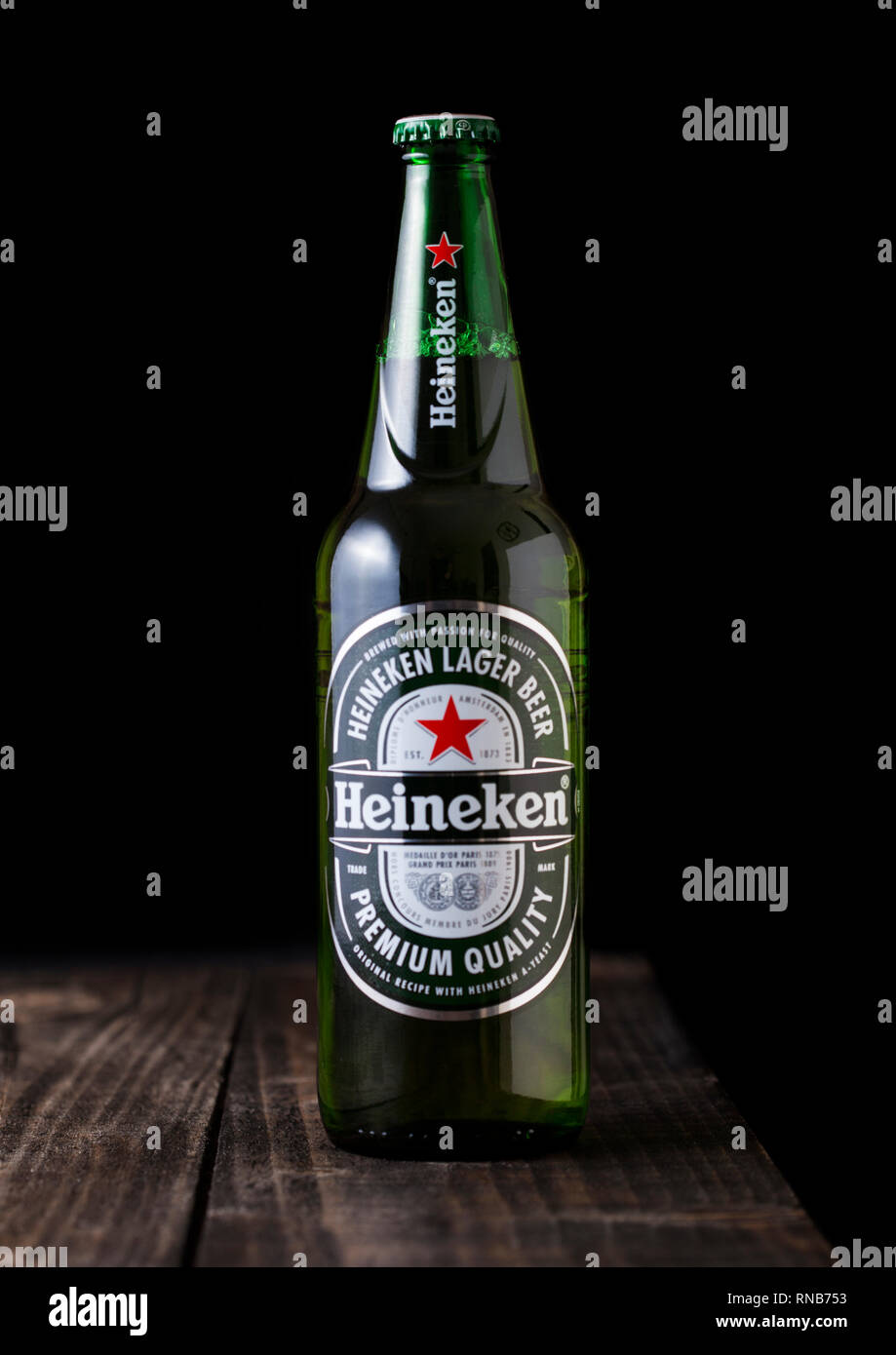 LONDON, UK - FEBRUARY 06, 2019: Bottle of Heineken Lager Beer on dark wooden background. Heineken is the flagship product of Heineken International Stock Photo