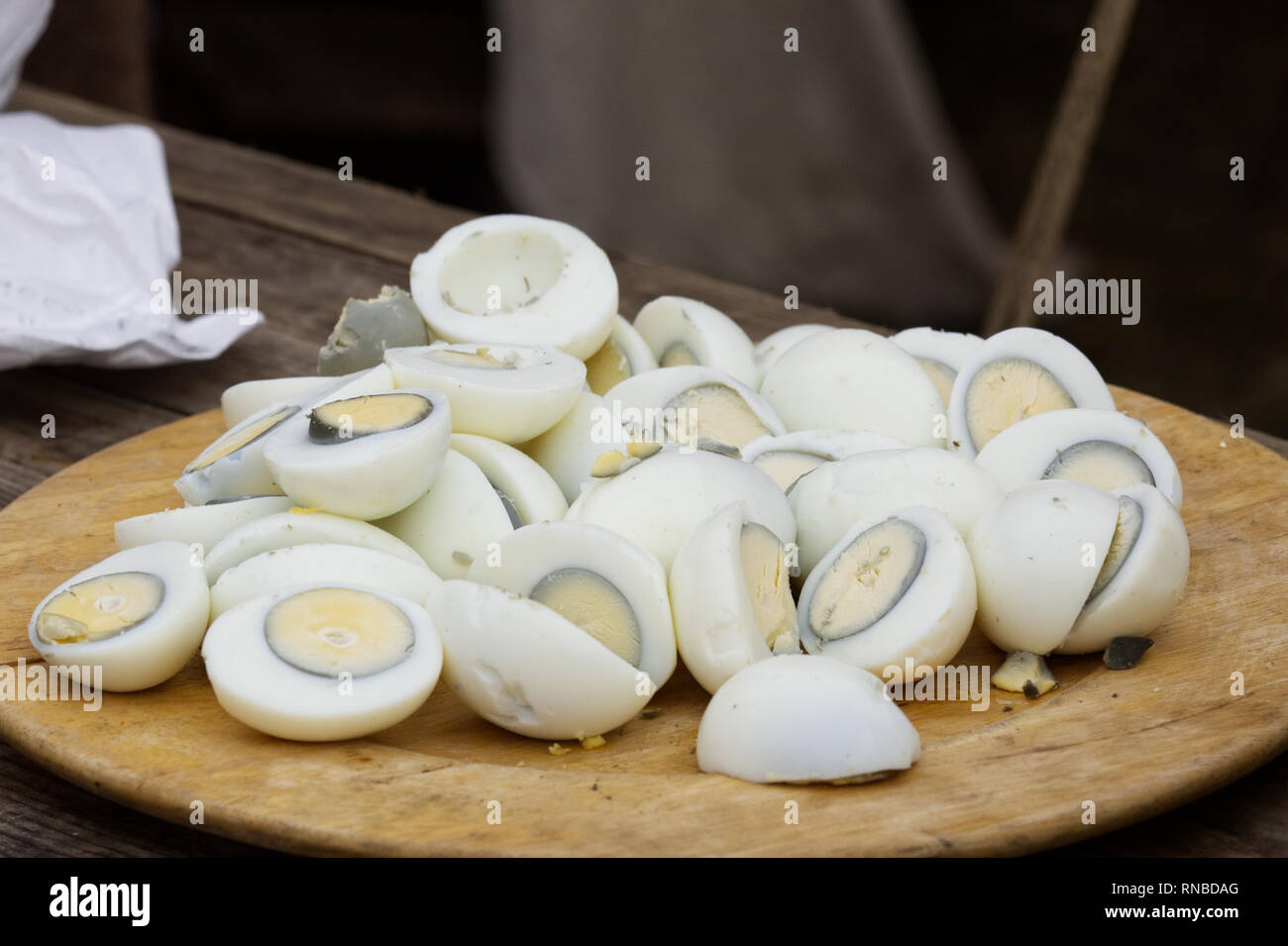 overcooked boiled eggs with iron around the rim of yolk on a wooden platter Stock Photo