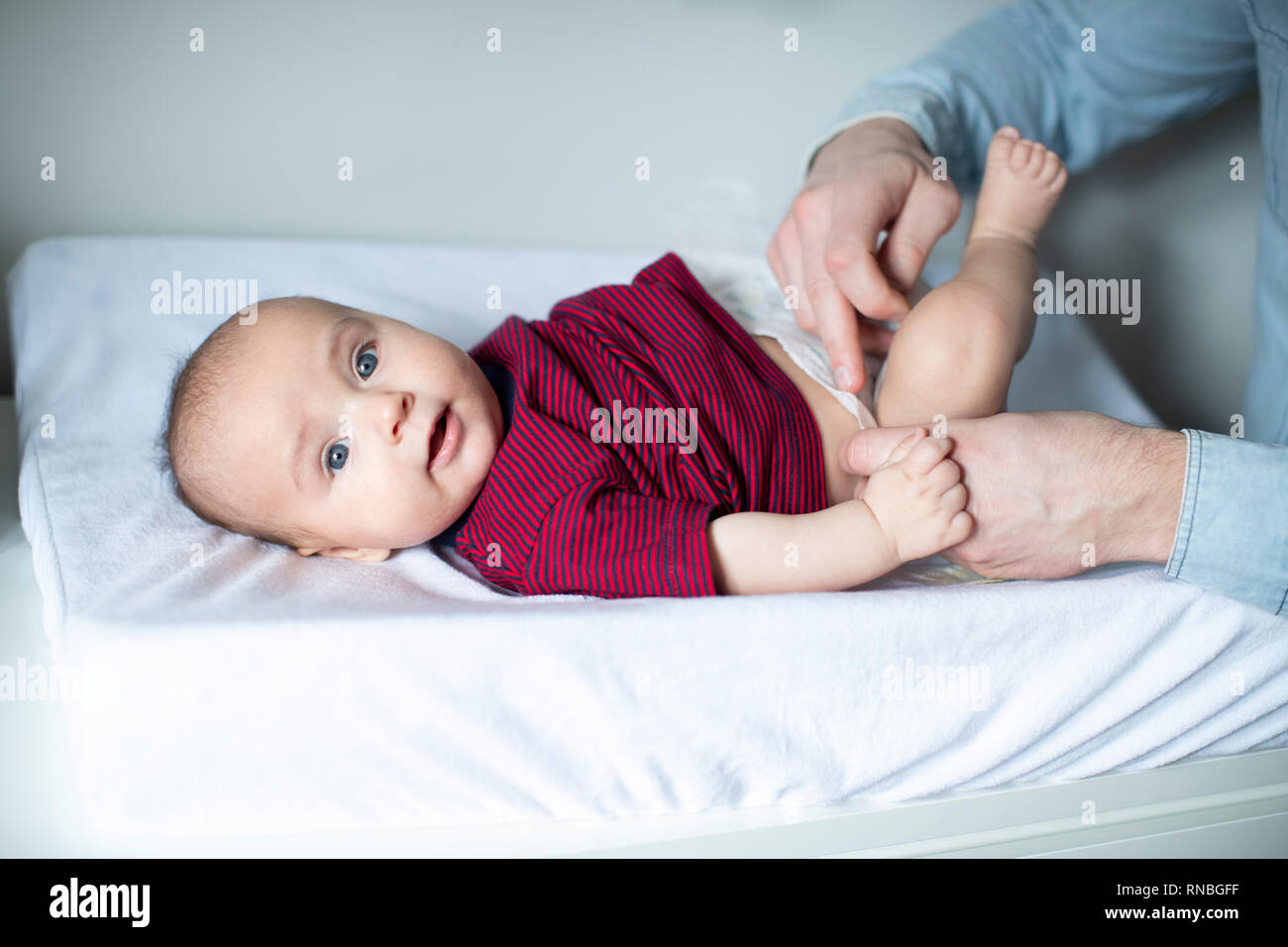 Close Up Of Father In Nursery At Home Changing Baby Sons Daiper Stock Photo