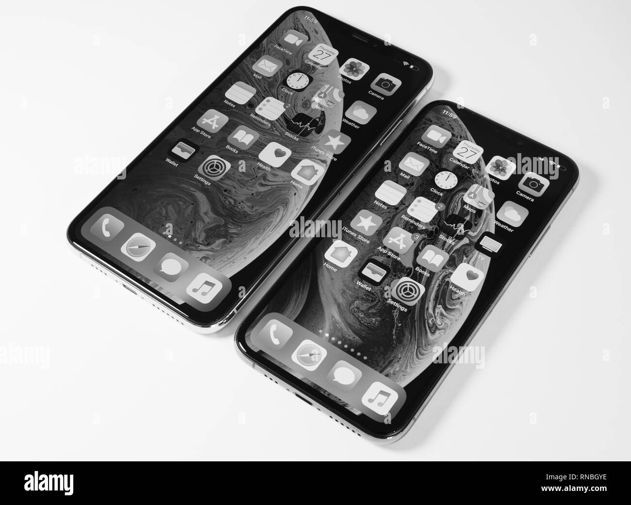 PARIS, FRANCE - SEP 27, 2018: Compare the new Apple Computers iPhone Xs and Xs Max as hero object on bright glamorous modern neon pop yellow background - smartphone black and white Stock Photo