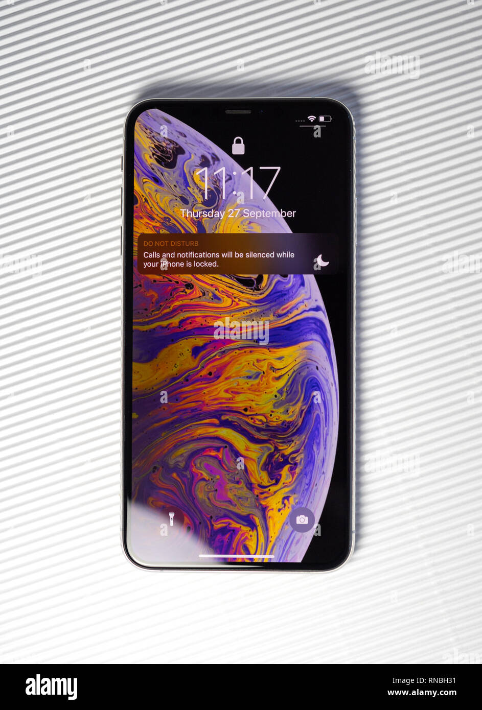 PARIS, FRANCE - SEP 27, 2018: new iPhone Xs Max smartphone model by Apple Computers close up with lock screen and wallpaper isolated Stock Photo