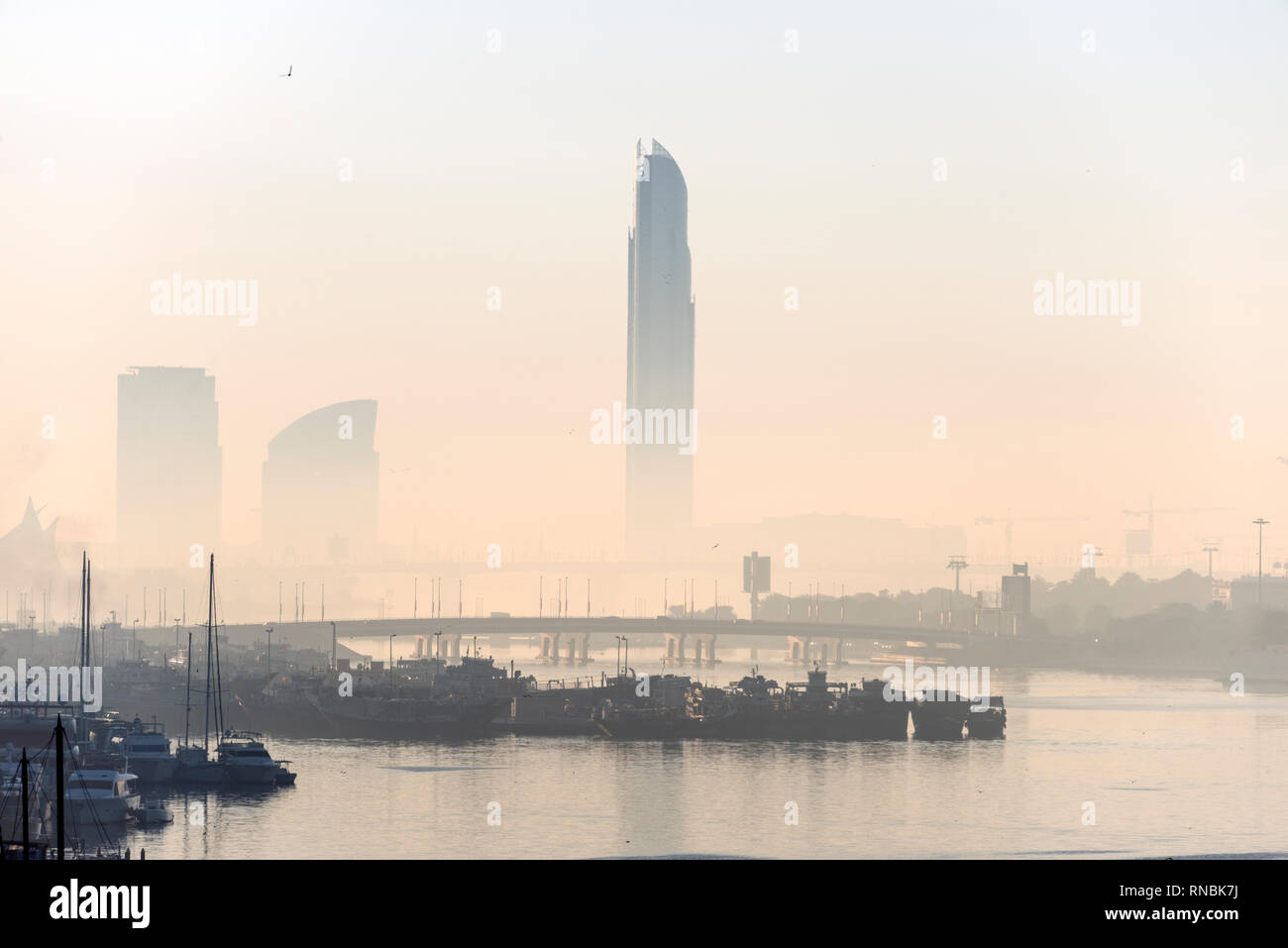 Sunrise with a layer of heat haze over the Dubai Creek in Dubai, in the United Arab Emirates, (UAE) Stock Photo