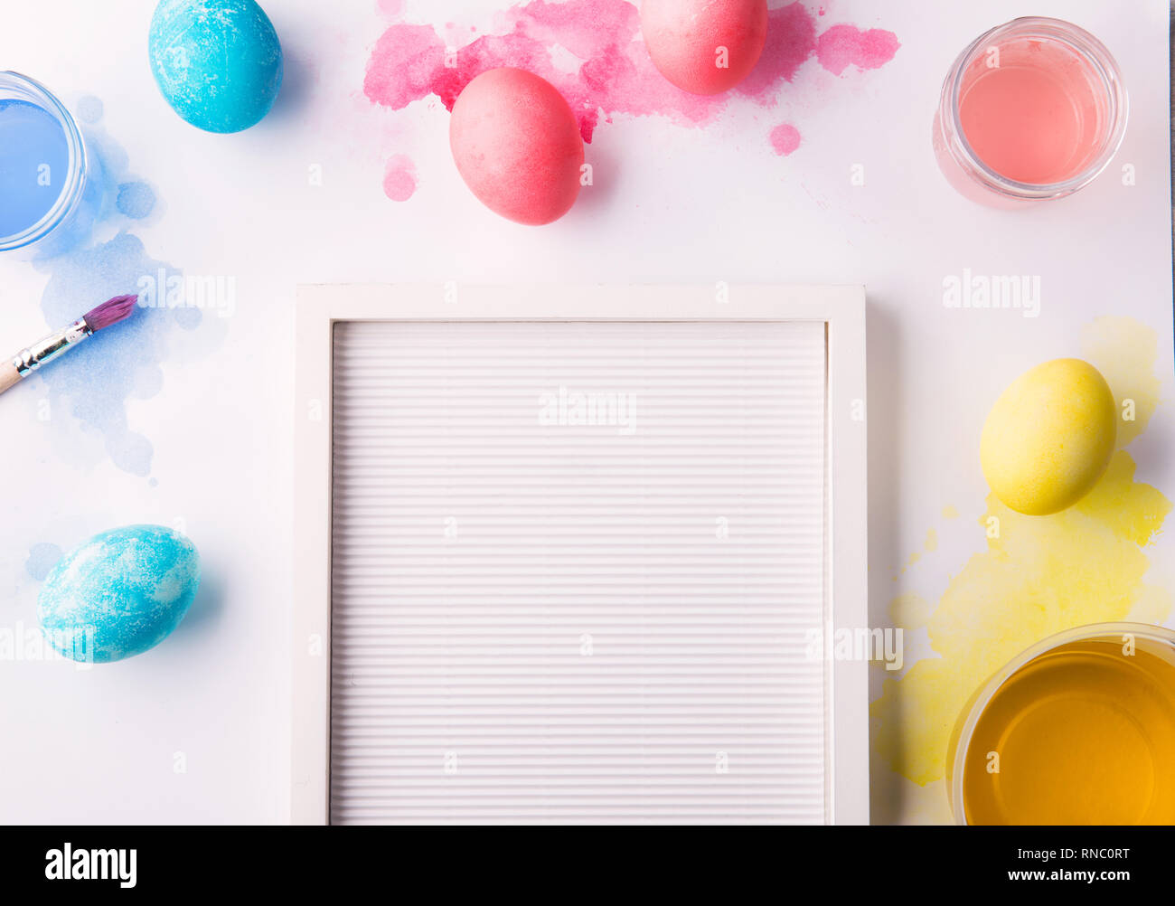 Painted eggs flat lay on a white background. Easter and spring composition. Copy space. Stock Photo