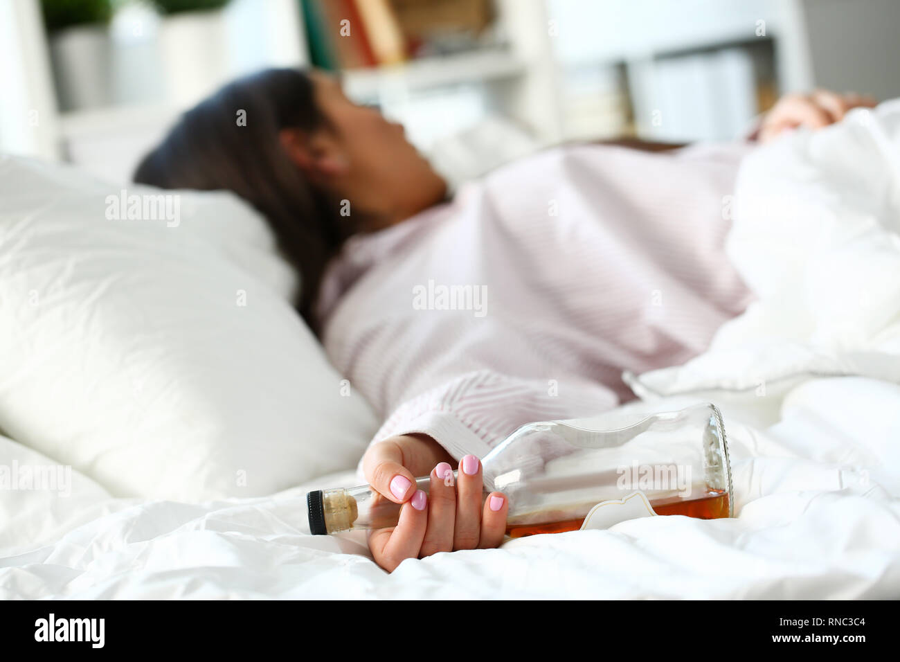 Young woman lying in bed deadly drunken Stock Photo