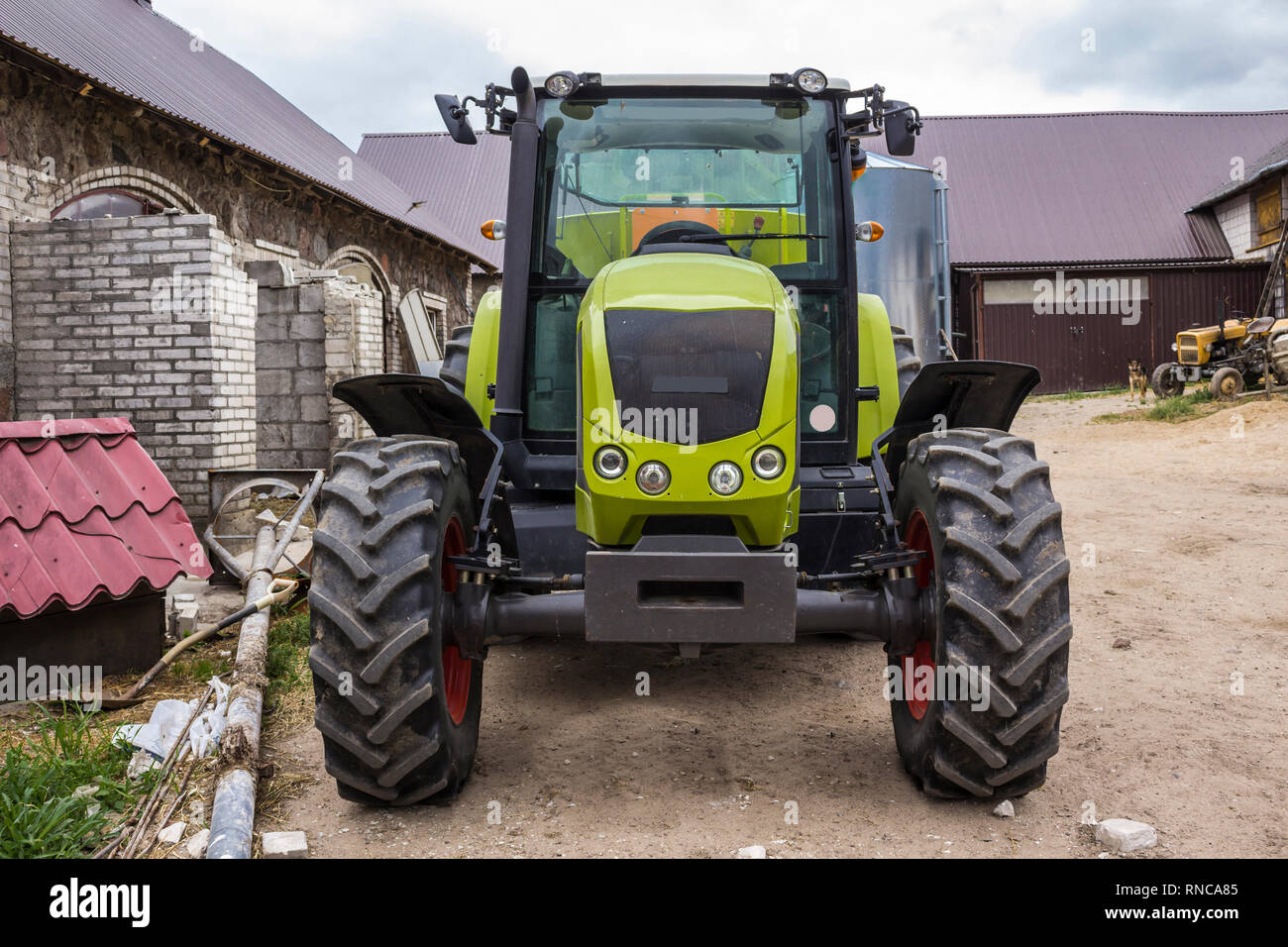Front view of a powerful tractor for various agricultural works. Necessary equipment for a dairy farm. Stock Photo