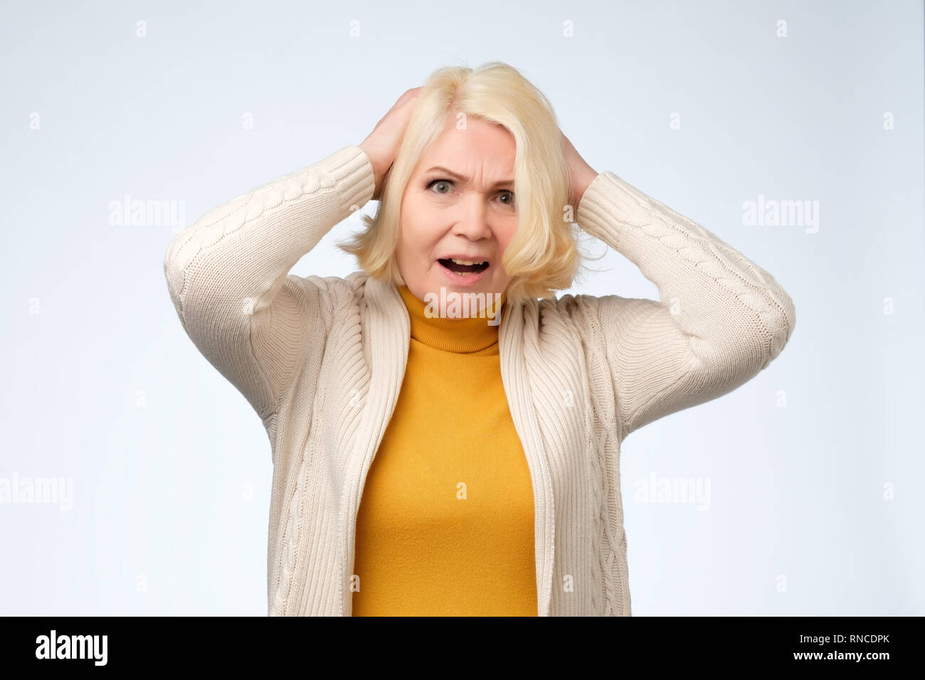 Sad old senior woman looking down and crying Stock Photo