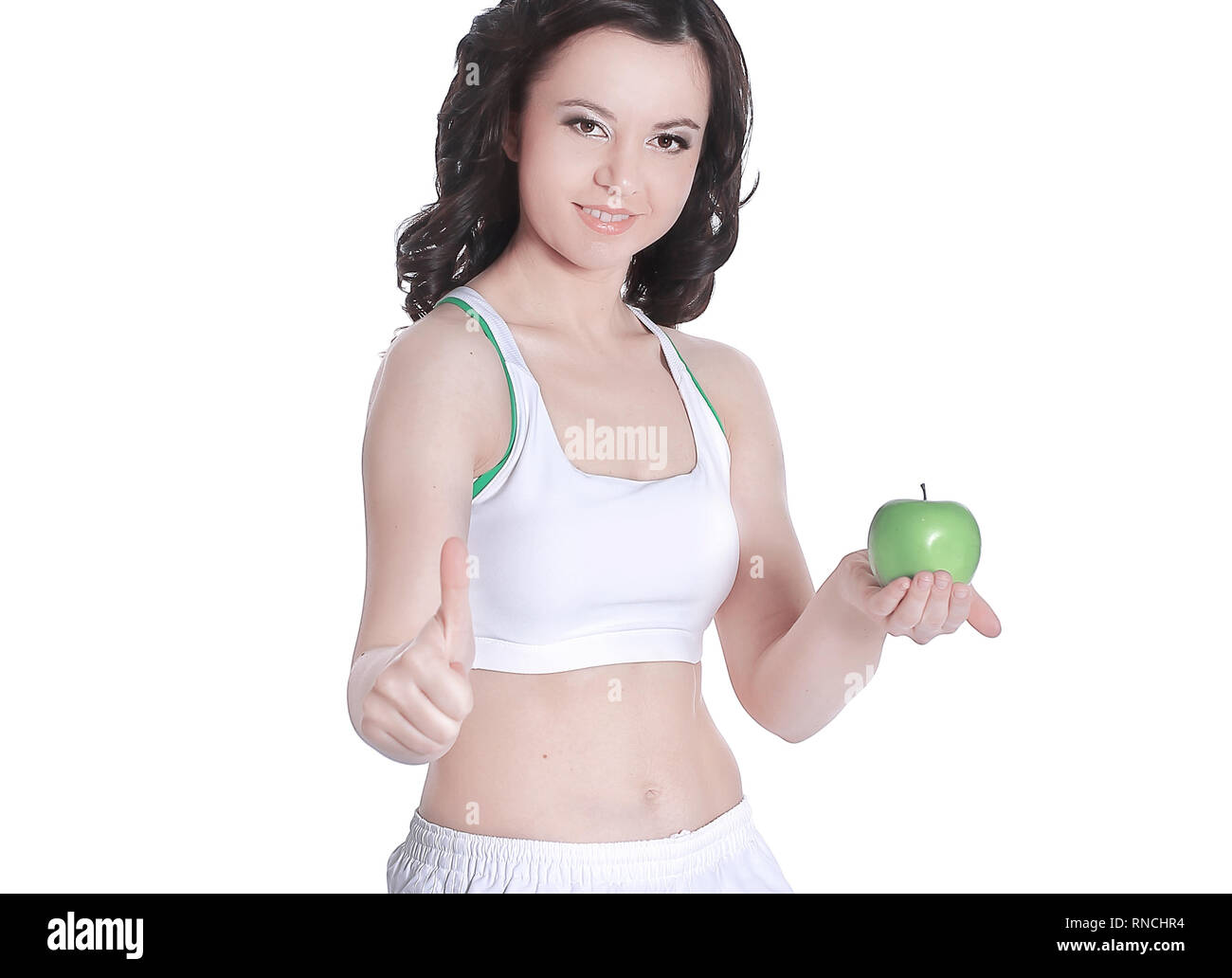 Beautiful woman holding green Apple shows thumb up Stock Photo