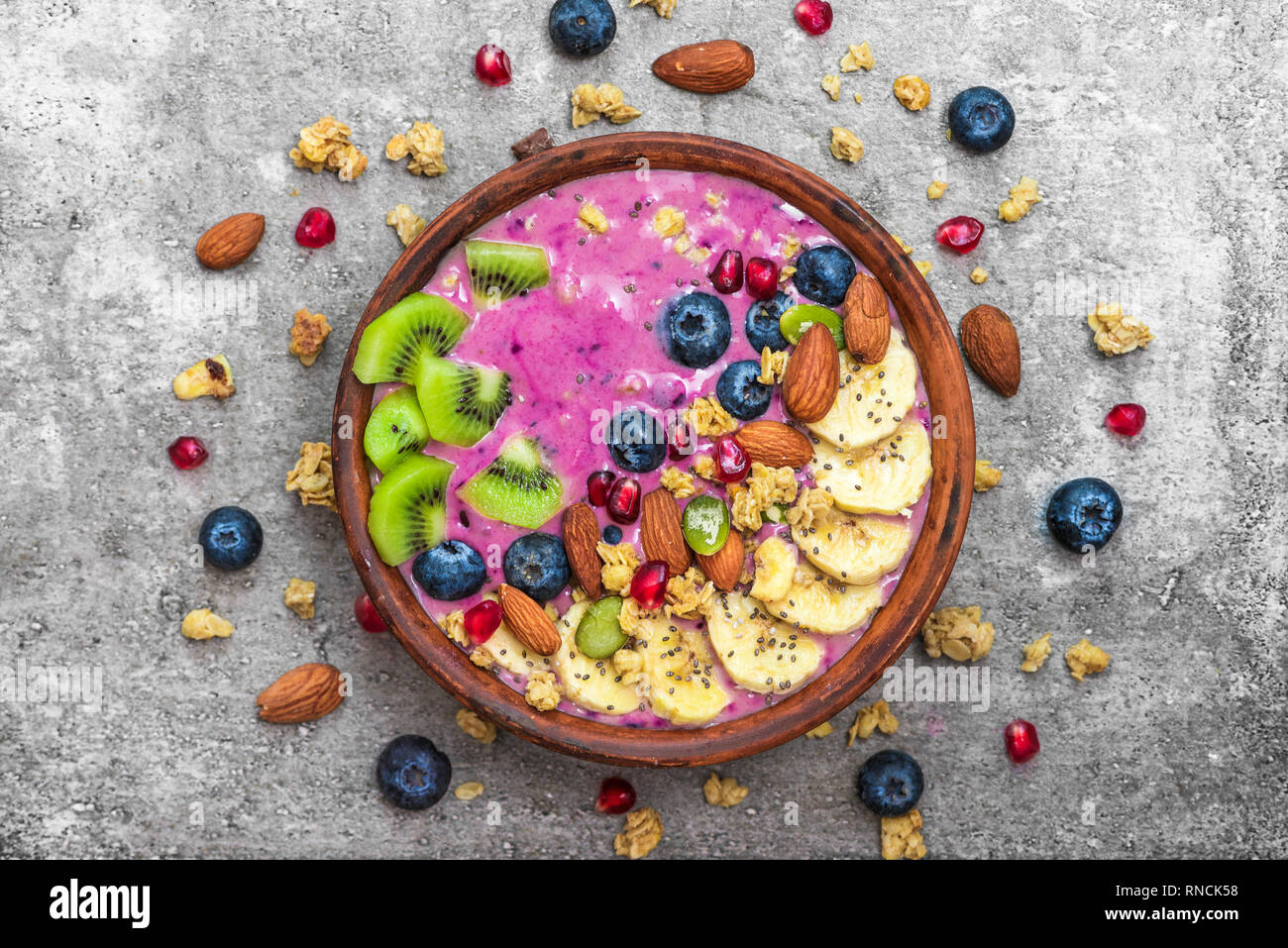 Smoothie bowl with fresh berries, fruits, nuts, seeds and homemade granola for healthy vegan vegetarian diet breakfast. top view Stock Photo