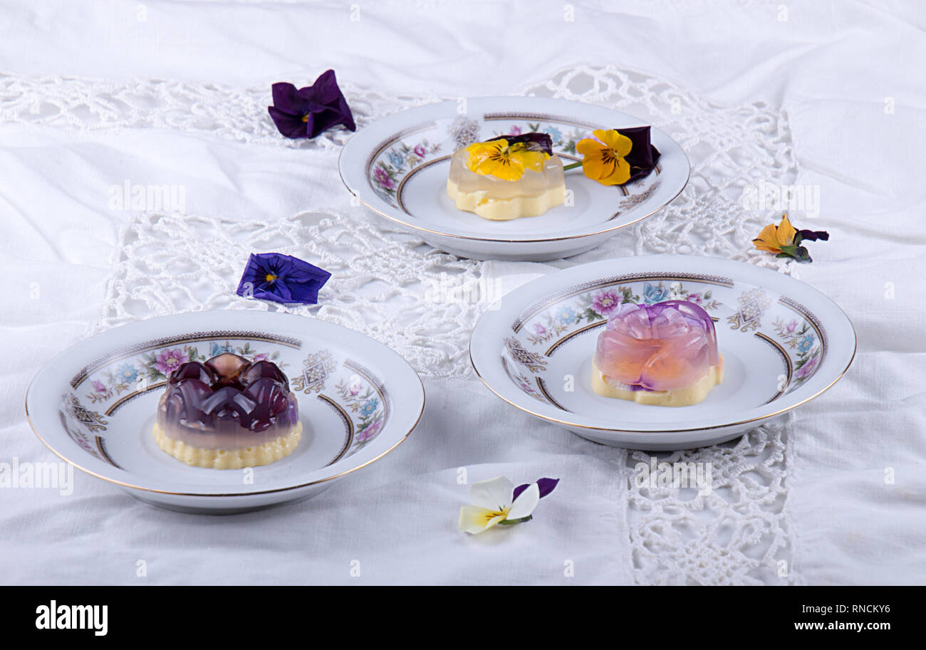 Unique japanese dessert Havaro of jelly and bavarian cream with edible violet flowers. Gelatin healthy eating dessert. Stock Photo