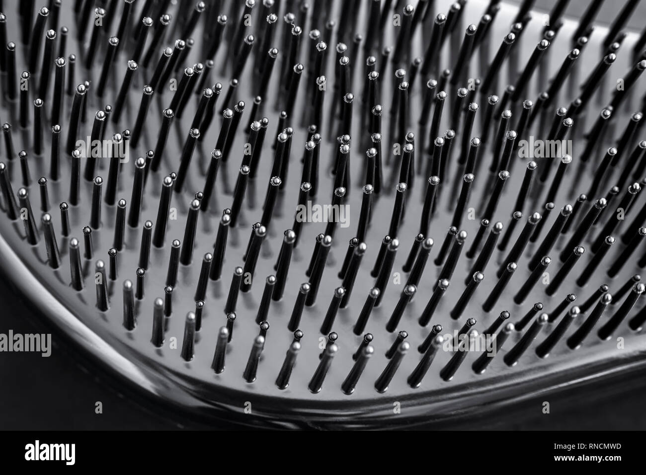 Close-up of bristles on black hairbrush. Black background. Stock Photo
